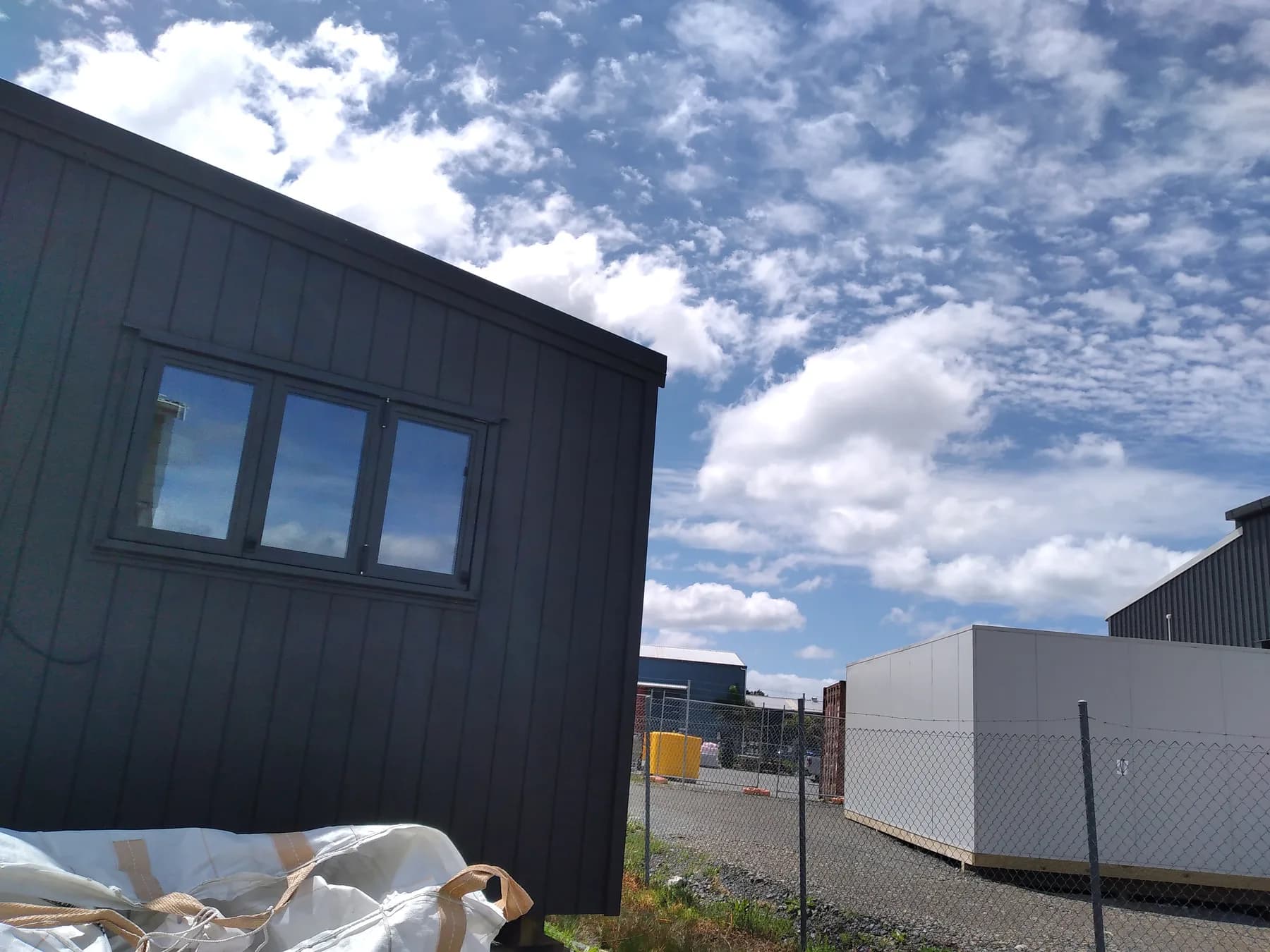 Dark-clad cabin standing in the Silverdale yard under a big sky