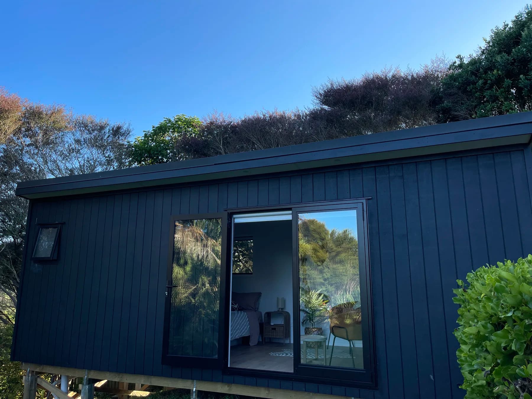 Dark-clad cabin with the ranchslider open onto the yard