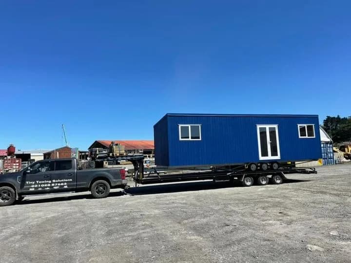 A blue-clad KDL home loaded on a transporter, ready to leave the yard