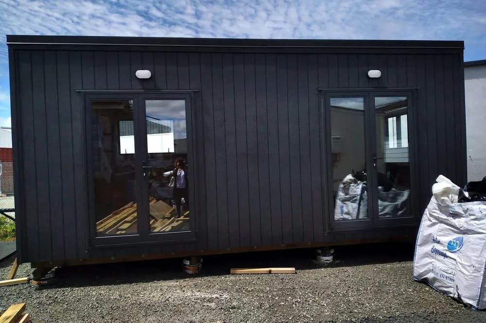 Dark-clad KDL cabin shell on site