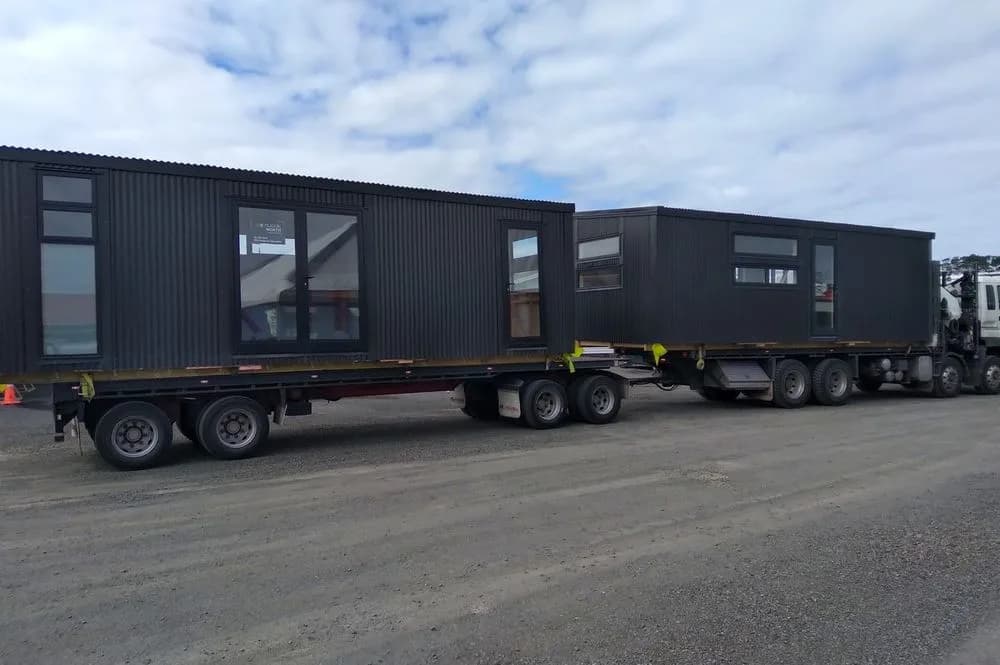 Two completed KDL tiny homes loaded on transporters for delivery